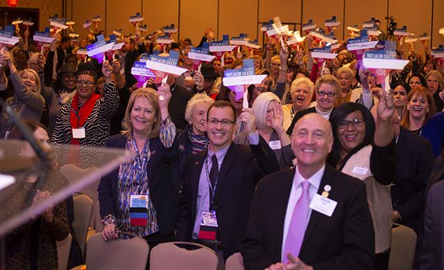 Texas REALTORS® at the 2020 Winter Meeting wave signs showing why they are proud members of the association.